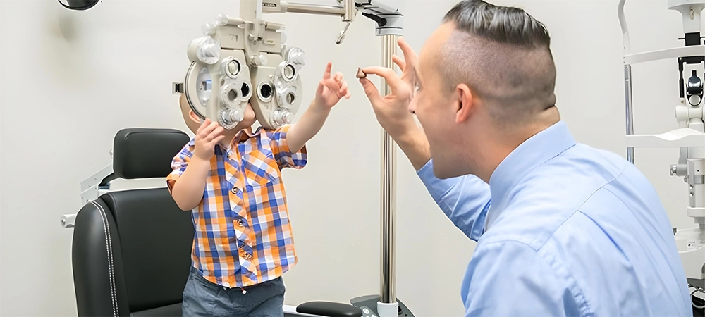 Young child undergoing eye test with optometrist using phoropter in clinic.