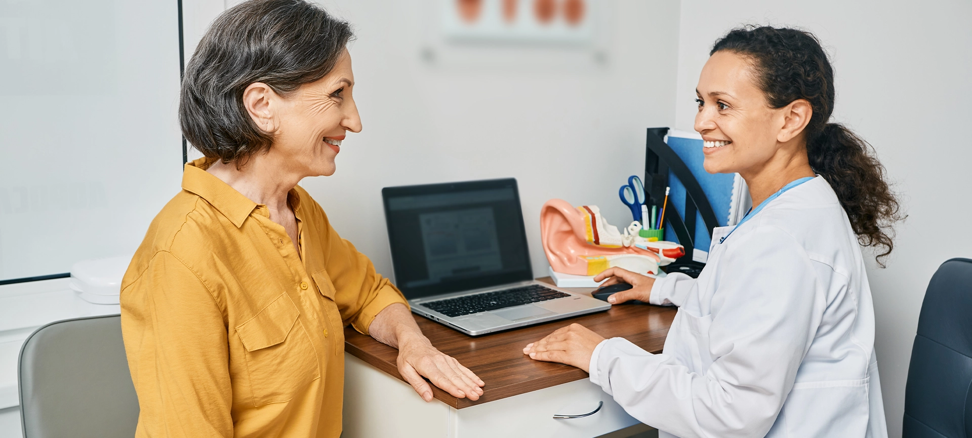 Consultation with experienced female audiologist to mature woman patient at medical clinic. Treatment of hearing loss in senior people