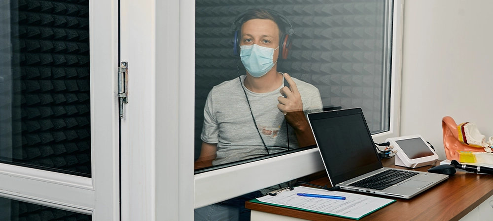 Adult man getting a hearing test at audiology center. Audiometry, hearing check up