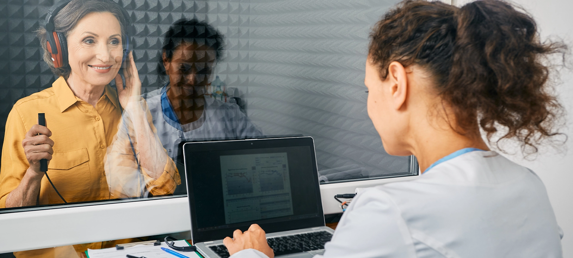 Mature woman getting a hearing test at audiology center. Audiometry, hearing checkup
