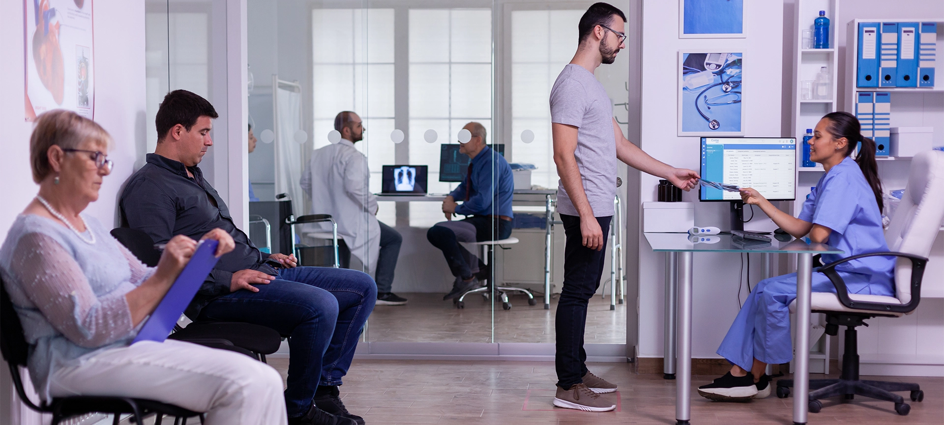 Crowded hospital waiting area with people filling form for medical consultation, young man giving xray to nurse, making new appointment. Specialist doctor consulting senior man in examination room.