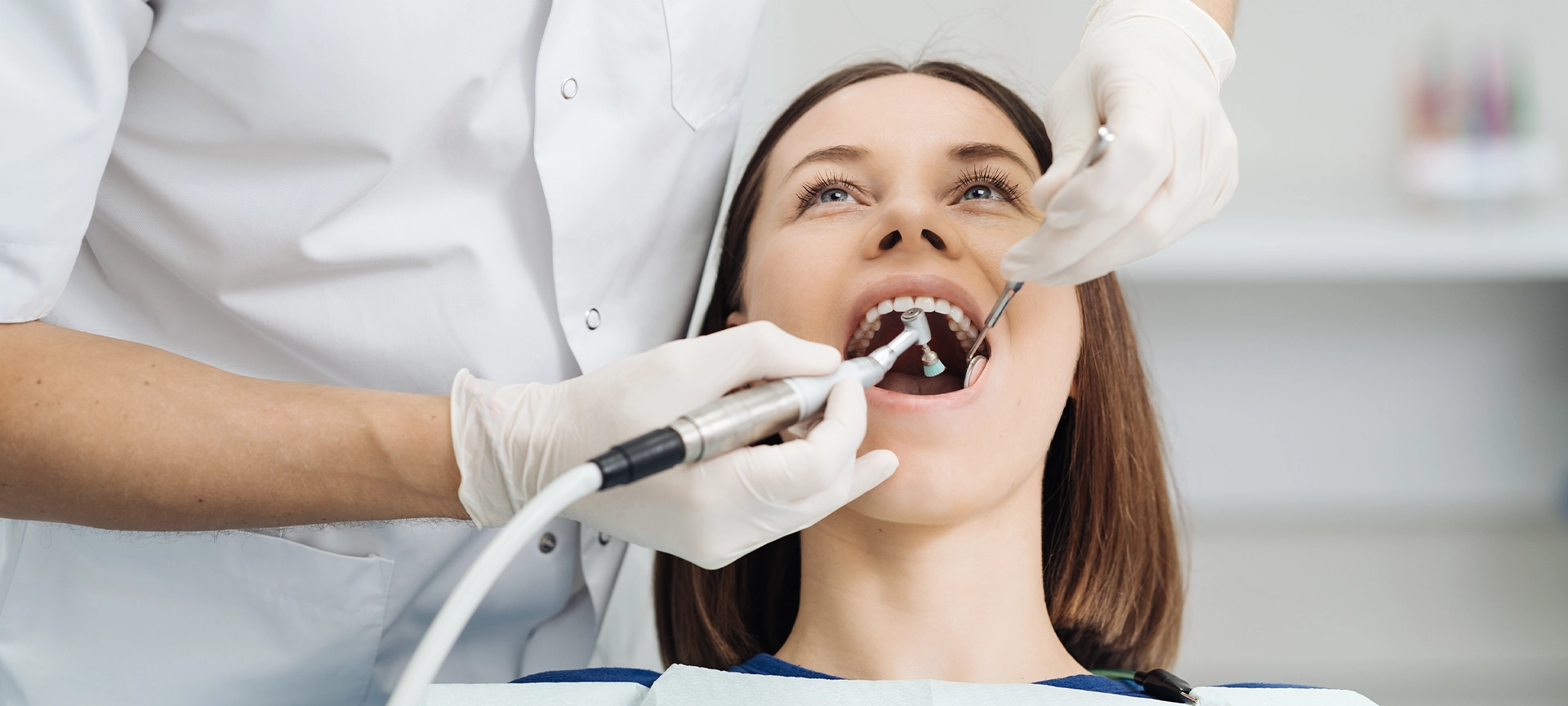 Overview of dental caries prevention, Girl at the dentist chair during a dental scaling procedure, Healthy Smile.