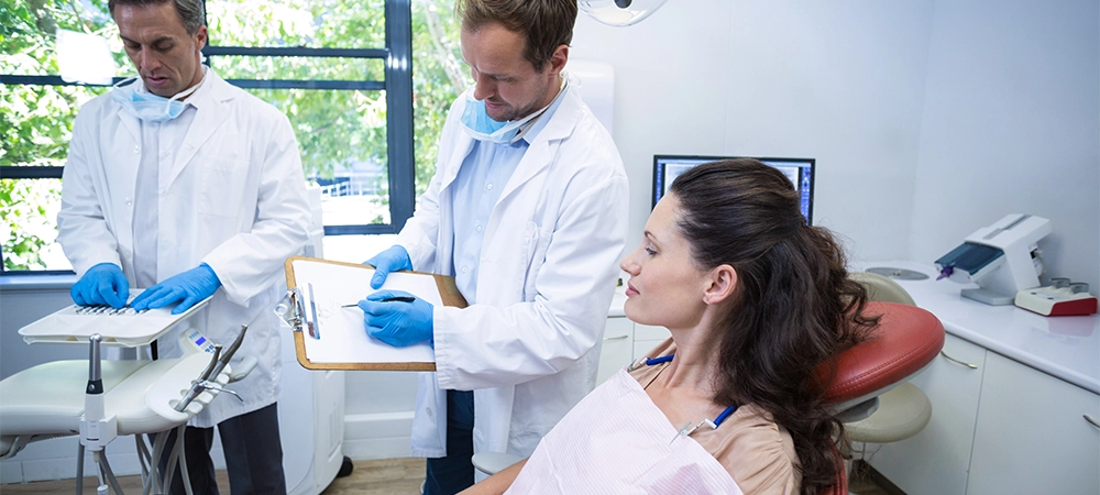 Dentist interacting with female patient at dental clinic