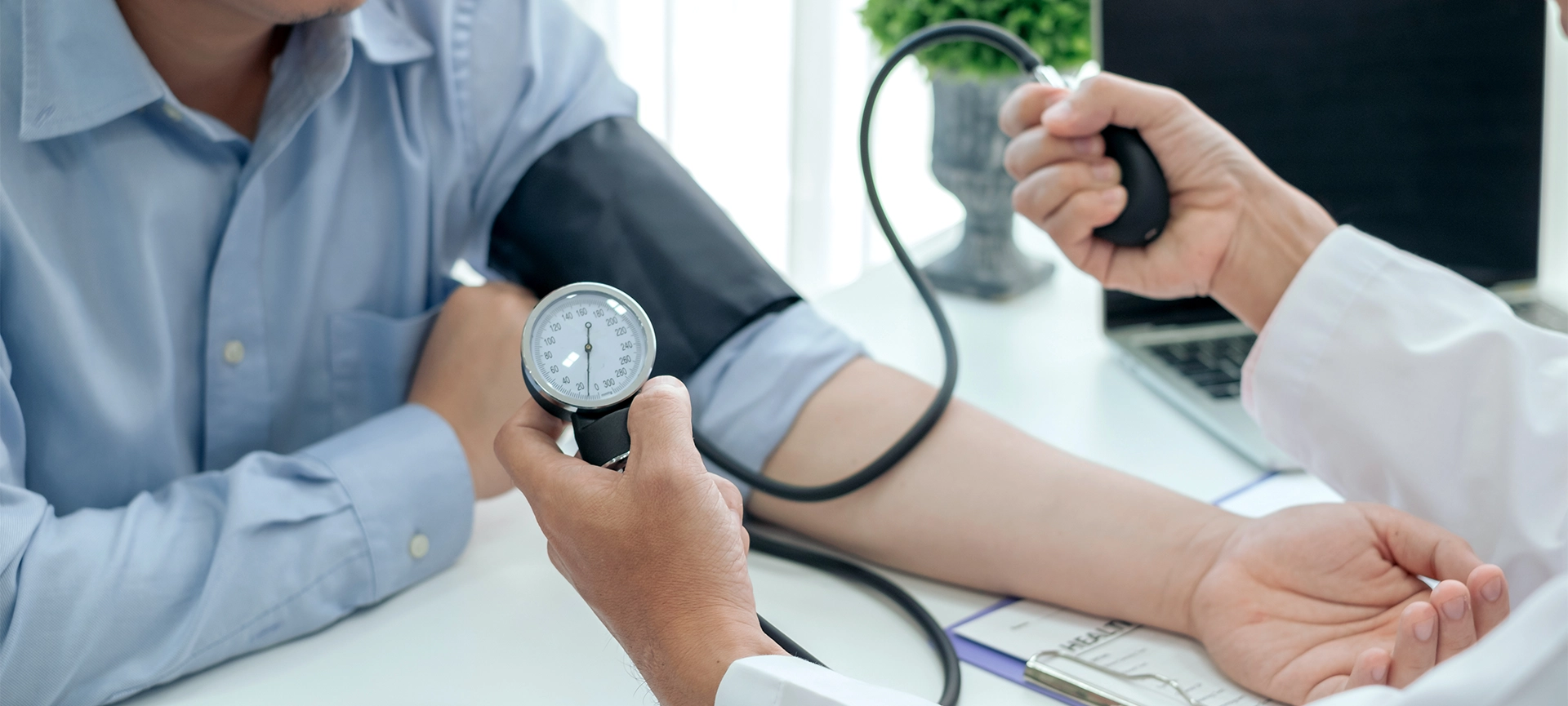 Doctor man is checking the blood pressure of the patient.