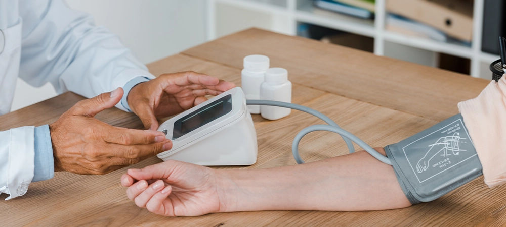 cropped view of doctor gesturing while measuring blood pressure of woman