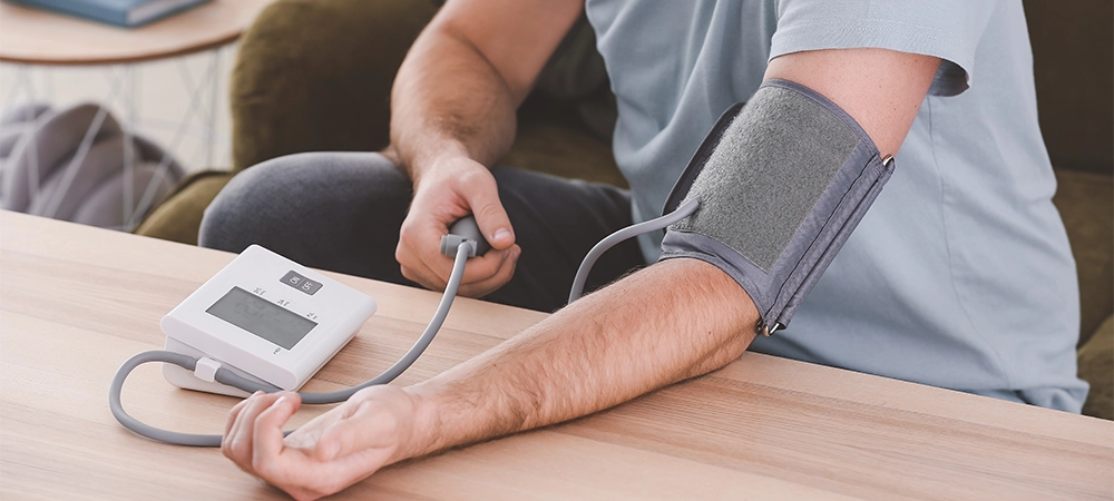 Young man measuring his blood pressure at home