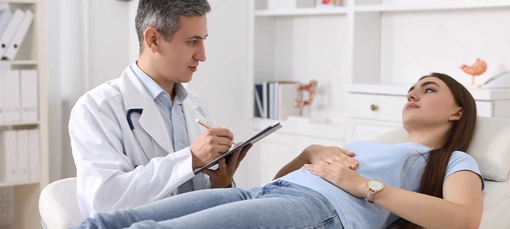 Gastroenterologist with clipboard consulting patient in clinic