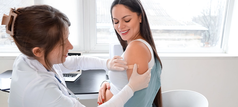 Young pregnant woman receiving medical patch after vaccination at hospital