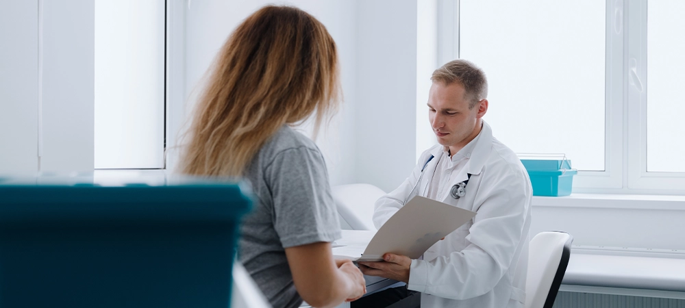 Patient's appointment with a doctor. A male doctor in a white coat reads a patient's medical record.